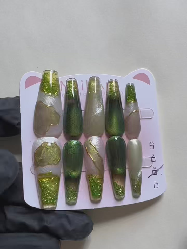 Load video: Emerald Pool Hand Drawn Elaborate Satin Gold Outline Emerald Cat Eye Flowing Sand Nail Art